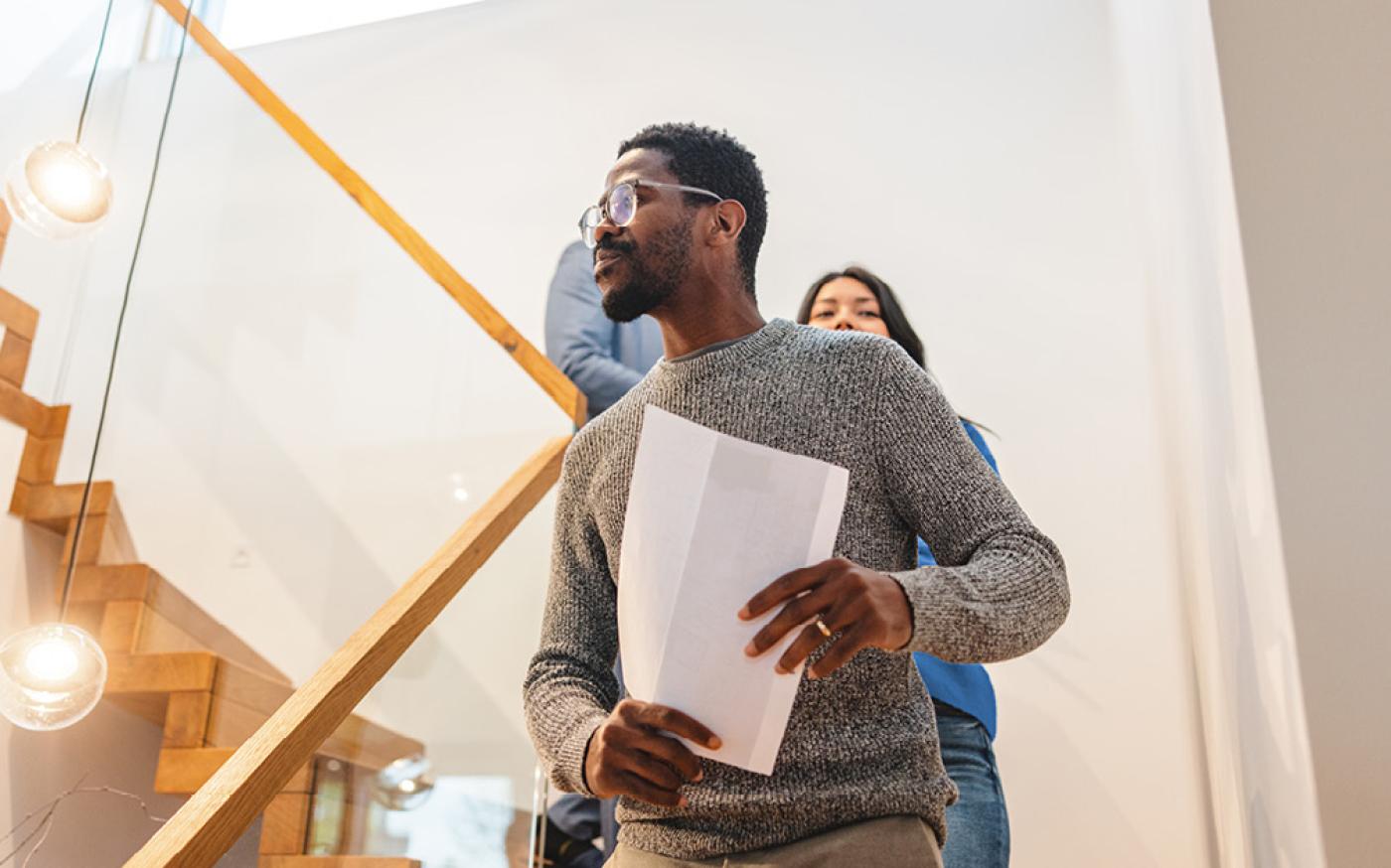 Man walking down stairs holding paper